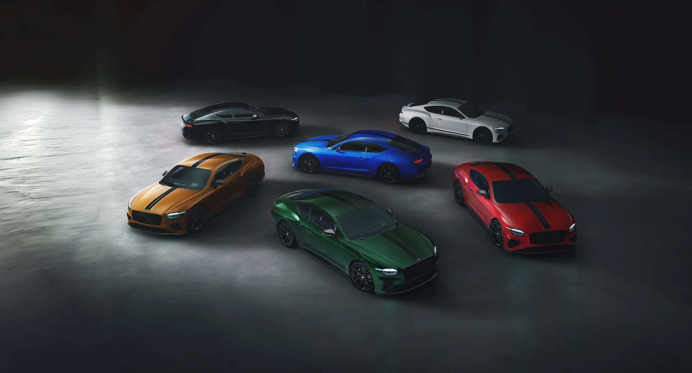 Six Bentley Continental GTs of the Bespoke Series by Mulliner arranged on a dark studio ground.
