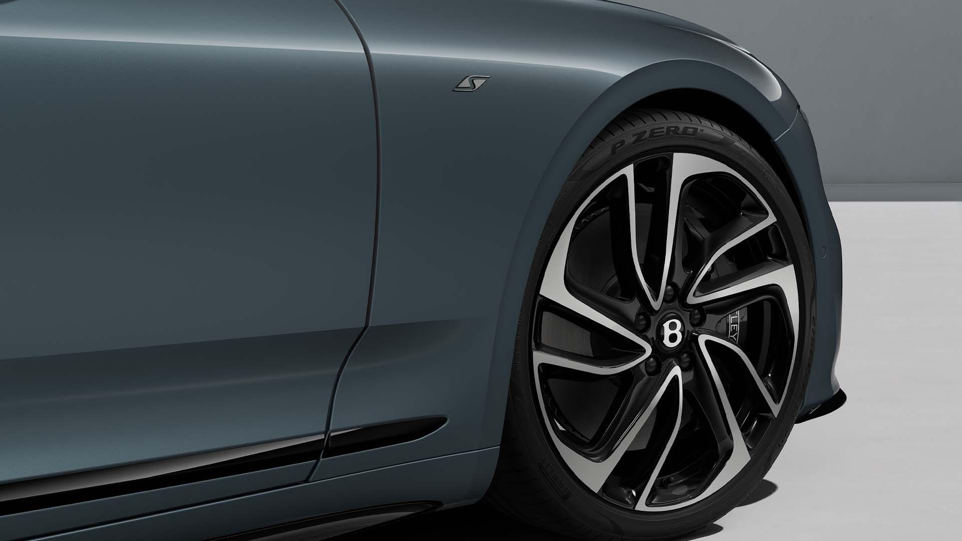The front wheel and tyre of a Bentley Continental GT S, the winged centre cap in the middle of the machined rim.